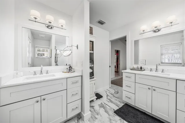 a spacious en suite bathroom with double sink a and a mirror