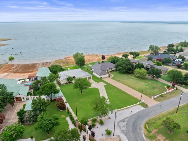 an aerial view of ocean with residential house and outdoor space