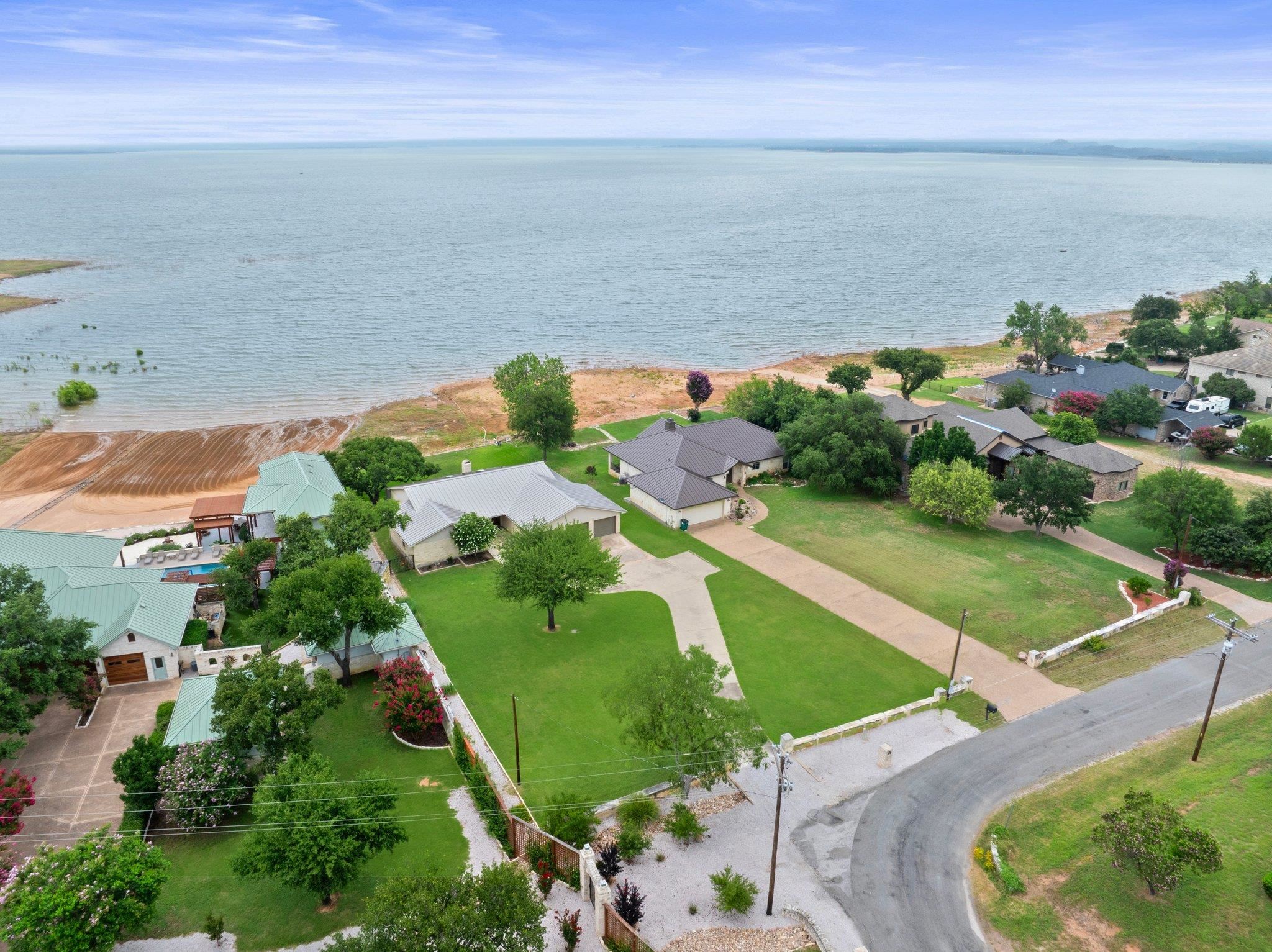 an aerial view of ocean with residential house and outdoor space