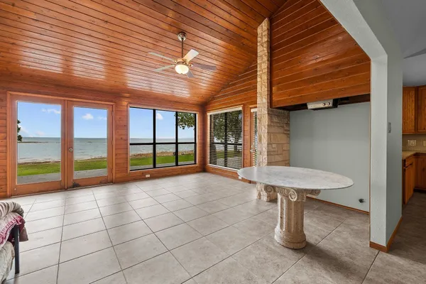 an empty room with windows and ceiling fan