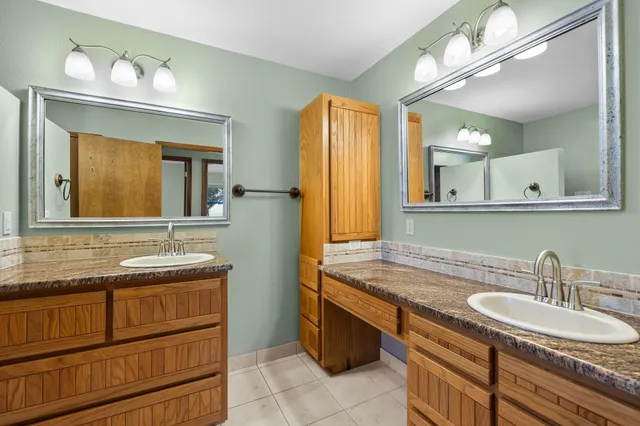 a bathroom with a granite countertop sink and a mirror