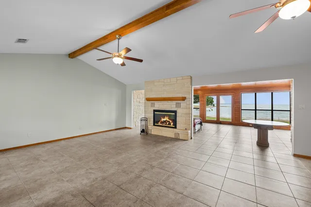a view of an empty room with a fireplace and a window