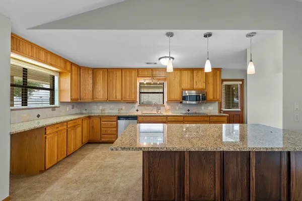 a kitchen with stainless steel appliances granite countertop a sink a counter space and cabinets