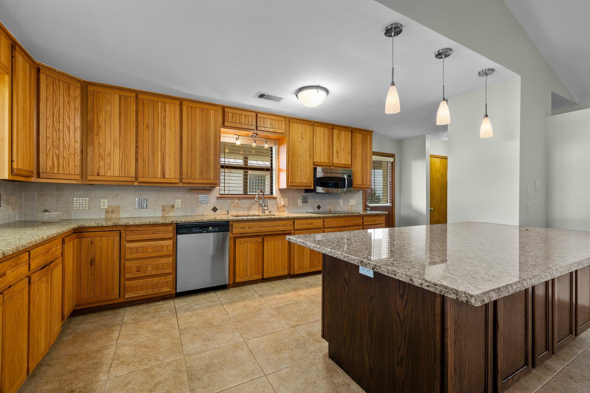 209 Senisa Drive Buchanan Dam, TX 78609 - Photo 10 of 30 a kitchen with stainless steel appliances granite countertop a sink a counter space and cabinets