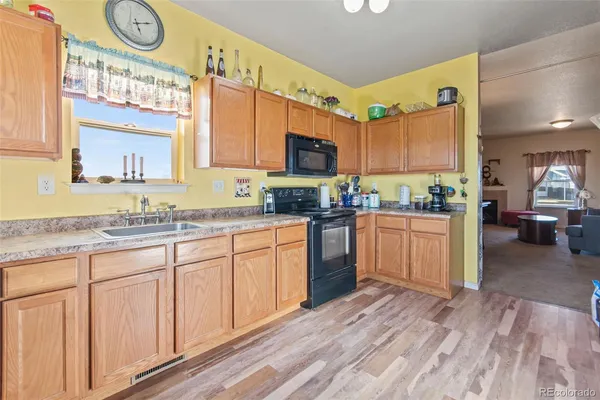 a kitchen with granite countertop a sink cabinets stainless steel appliances and a counter top space