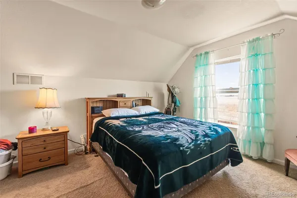 a bed sitting in a bedroom next to a window