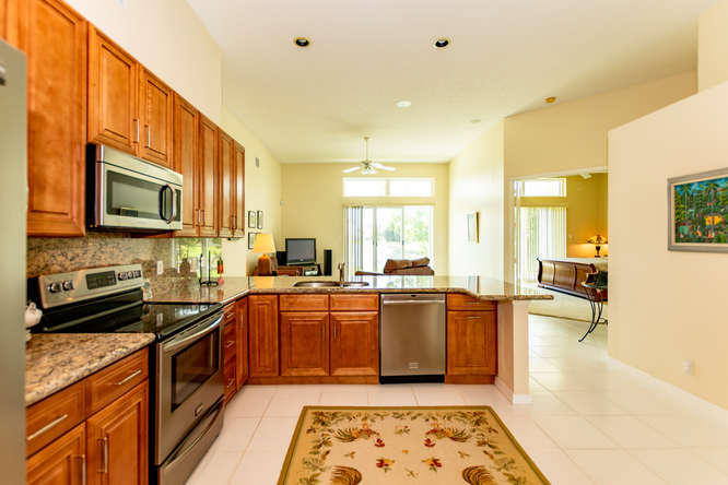 19627 Dinner Key Drive Boca Raton, FL 33498 - Photo 11 of 46 a kitchen with stainless steel appliances granite countertop a sink a stove top oven a chimney a dining table and chairs