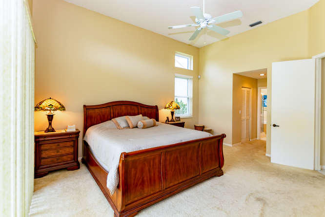 19627 Dinner Key Drive Boca Raton, FL 33498 - Photo 16 of 46 a bedroom with a bed and a chandelier