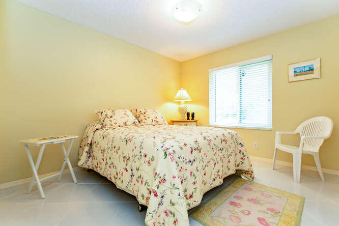 19627 Dinner Key Drive Boca Raton, FL 33498 - Photo 20 of 46 a bed sitting in a bedroom next to a window and chair