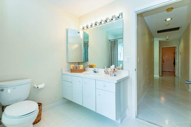 19627 Dinner Key Drive Boca Raton, FL 33498 - Photo 23 of 46 a bathroom with a toilet a sink a mirror and vanity
