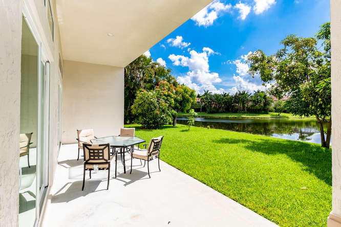 19627 Dinner Key Drive Boca Raton, FL 33498 - Photo 27 of 46 a view of a chairs and table in the patio next to a yard