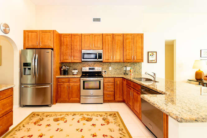 19627 Dinner Key Drive Boca Raton, FL 33498 - Photo 3 of 46 a kitchen with stainless steel appliances granite countertop a refrigerator a stove a sink and a microwave