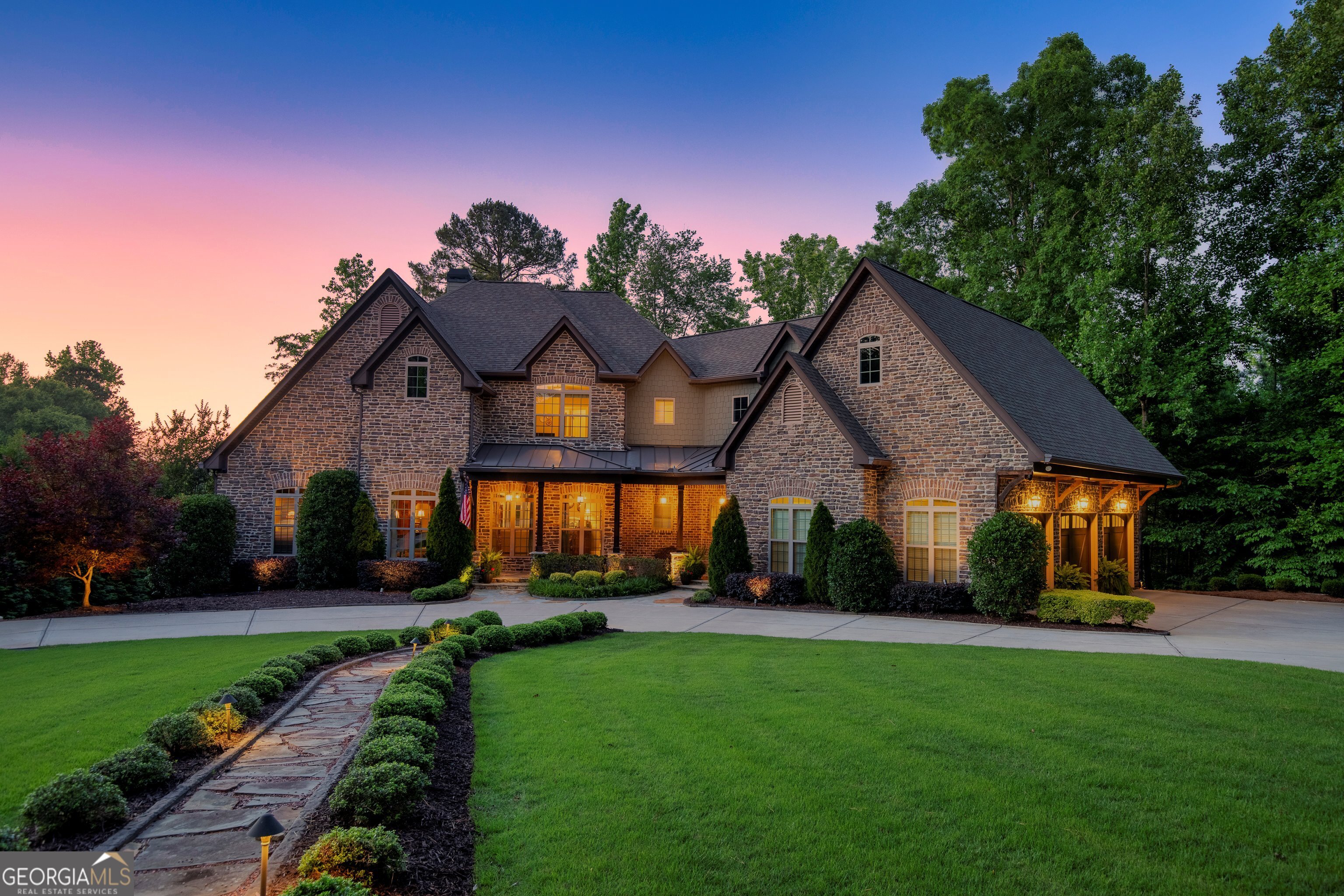a front view of a house with a yard and potted plants