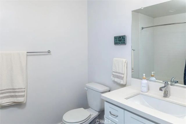 a bathroom with a granite countertop toilet sink and mirror