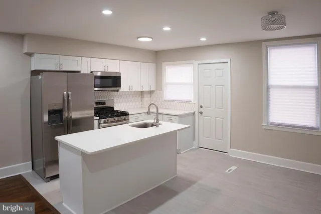 a kitchen with a sink a refrigerator a window and cabinets