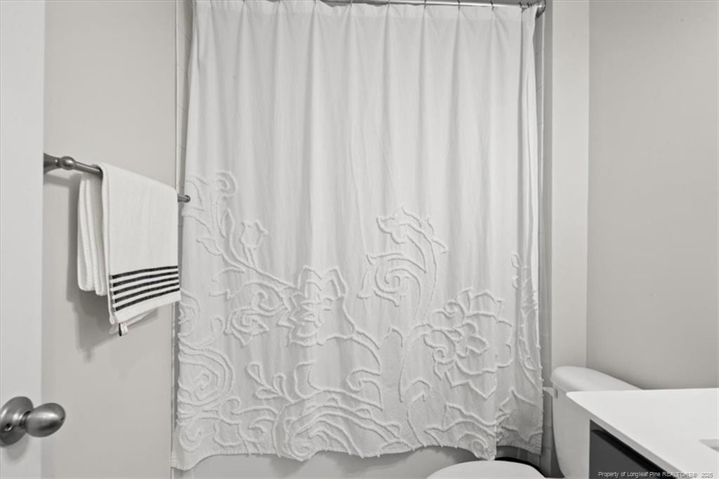 7840 Rufus Johnson Road Fayetteville, NC 28306 - Photo 13 of 50 a bathroom with a shower curtain