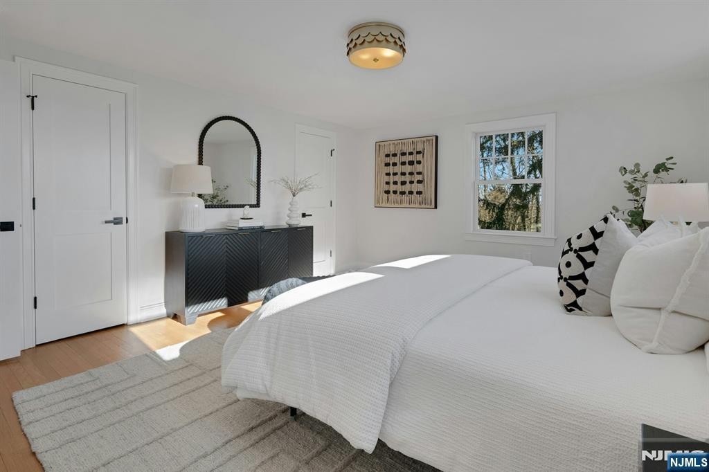 30 Edgecliff Road Montclair, NJ 07043 - Photo 23 of 46 a bedroom with a bed and a table with wooden floor