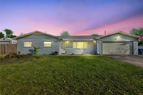 a front view of a house with a garden and yard