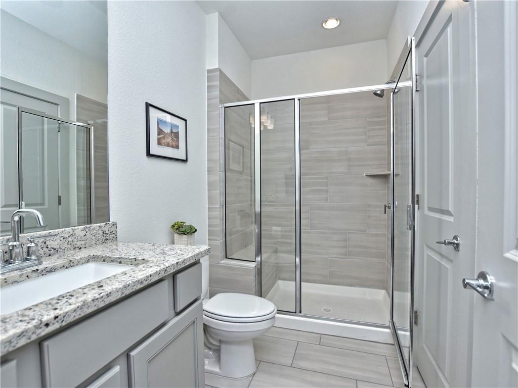 2172 Local Rebel Street Leander, TX 78641 - Photo 12 of 24 a bathroom with a granite countertop sink toilet and shower