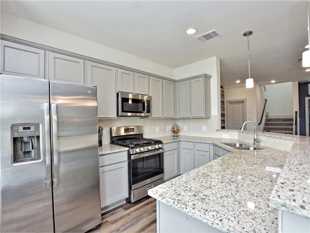 2172 Local Rebel Street Leander, TX 78641 - Photo 9 of 24 a kitchen with kitchen island granite countertop a sink appliances and cabinets