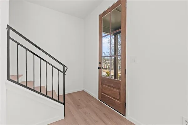 a view of a hallway with wooden floor and windows