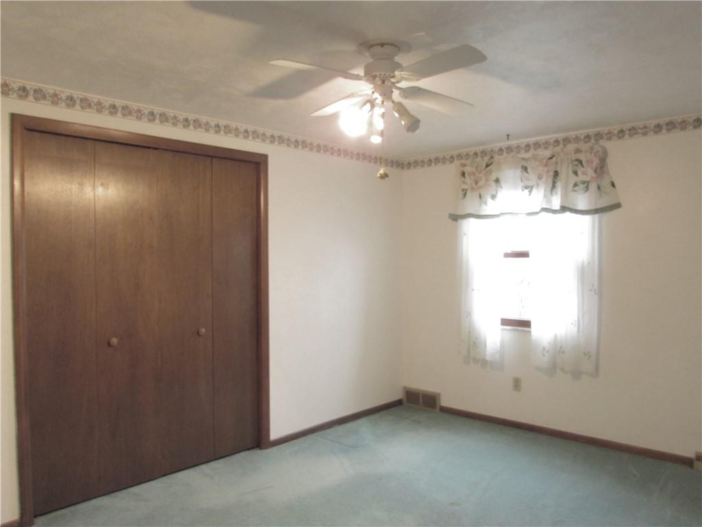 717 Blue Ridge Road Pittsburgh, PA 15239 - Photo 17 of 25 an empty room with a chandelier fan and windows
