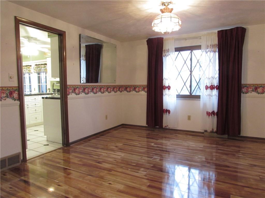 717 Blue Ridge Road Pittsburgh, PA 15239 - Photo 7 of 25 a view of an empty room with wooden floor and a window