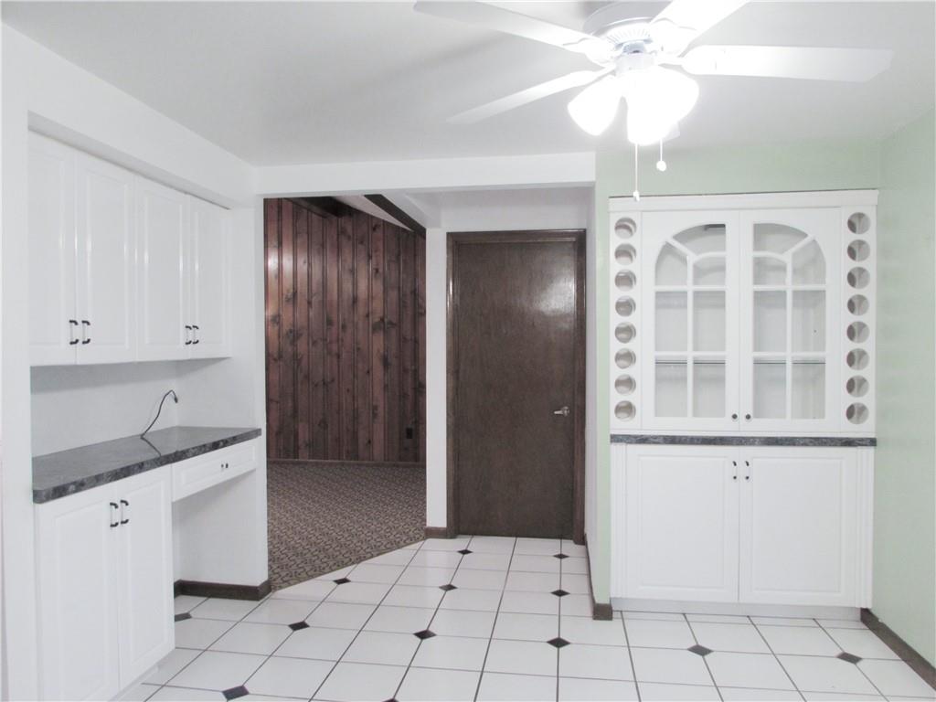 717 Blue Ridge Road Pittsburgh, PA 15239 - Photo 10 of 25 a kitchen with white cabinets and chandelier
