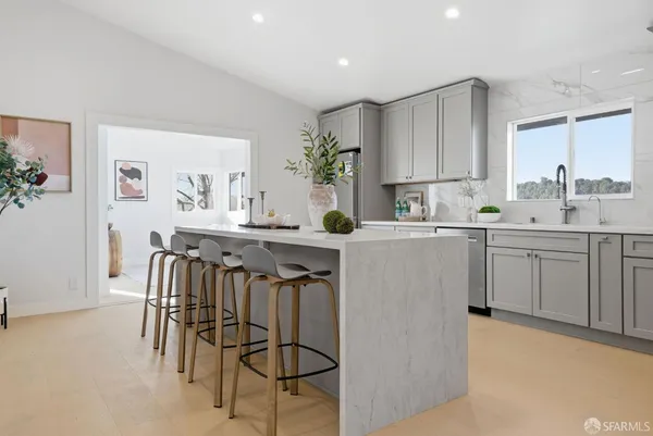 a kitchen with a sink chairs and cabinets