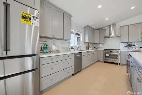 a kitchen with a refrigerator a stove a sink cabinets and wooden floor