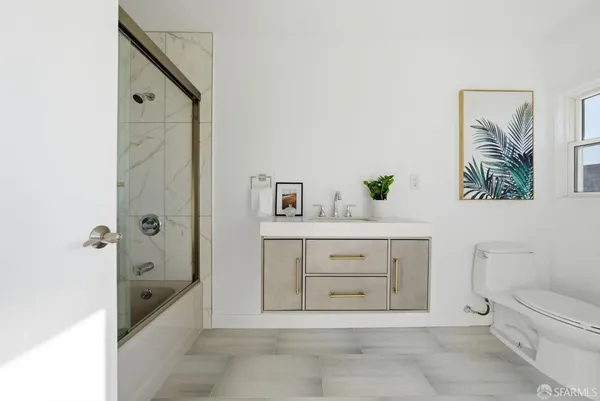 a bathroom with a granite countertop sink a toilet and shower