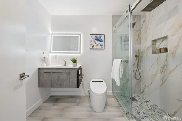 a bathroom with a granite countertop sink toilet and shower