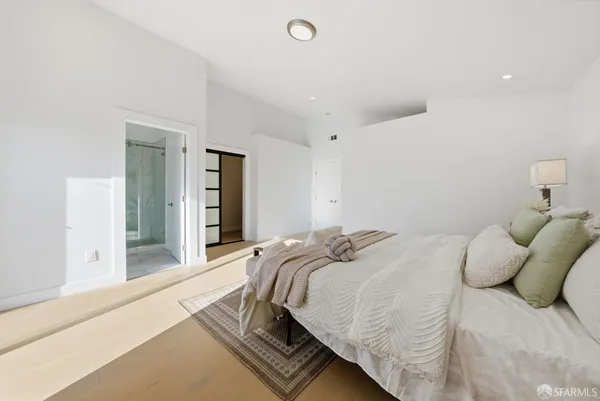 a bedroom with a bed and a large mirror