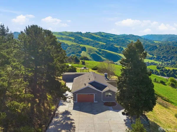 an aerial view of residential houses with outdoor space and trees