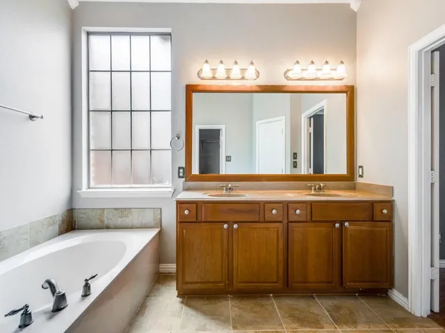 a bathroom with a tub sink and mirror