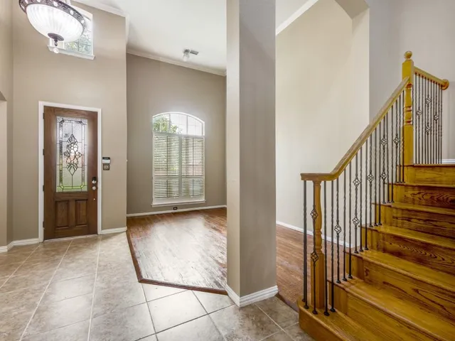 a view of a hallway with entryway and wooden floor