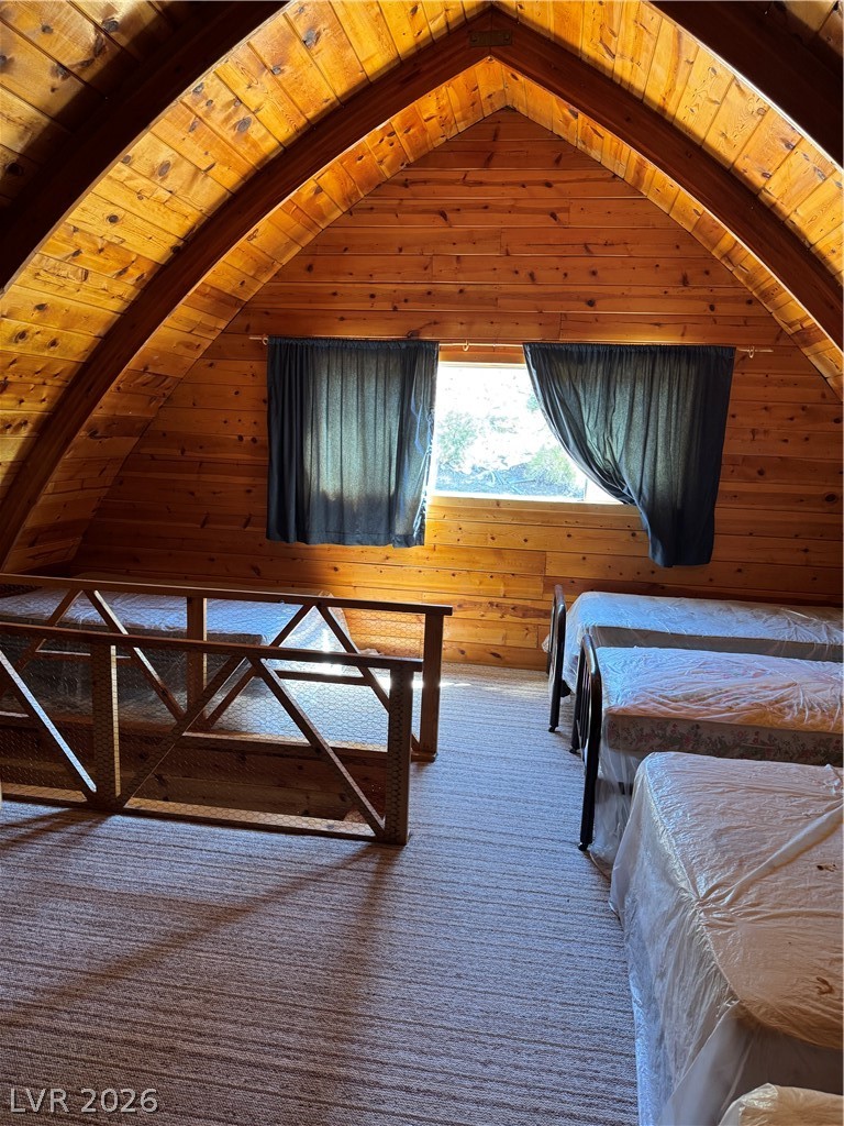 20996 Pinion Pine Road Pioche, NV 89043 - Photo 6 of 19 This cozy bedroom features warm wood paneling and a carpeted floor, offering a comfortable retreat.
