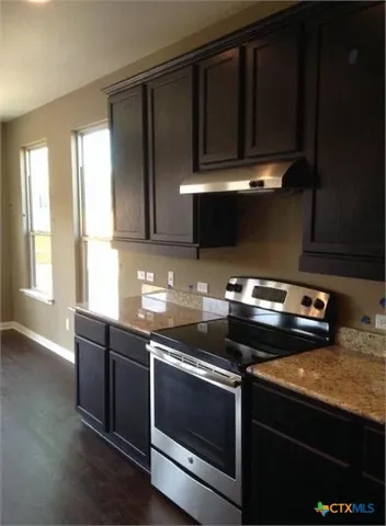 a kitchen with wooden cabinets and a stove top oven