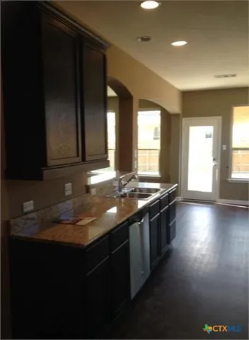 a kitchen with stainless steel appliances a sink dishwasher a stove and a refrigerator