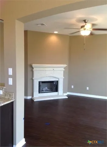 a view of a livingroom with a fireplace a chandelier and wooden floor