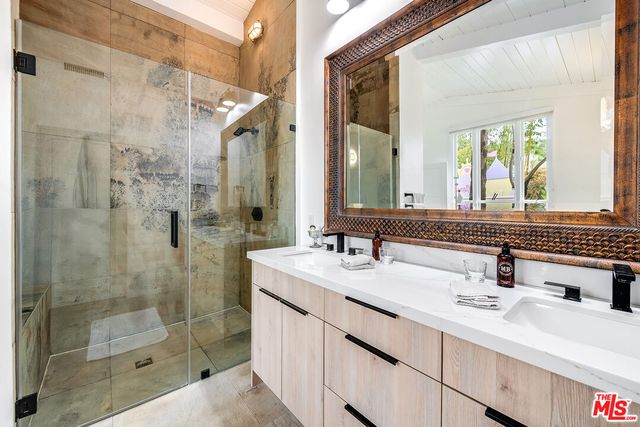 a bathroom with a shower sink and mirror