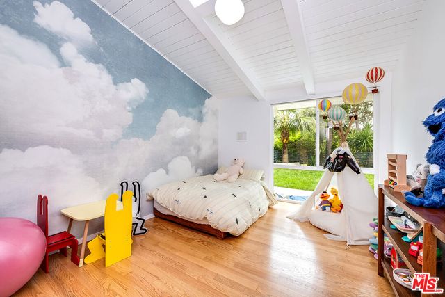 a bedroom with a bed and a wooden floor