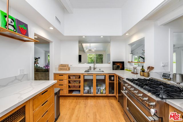 a large kitchen with stainless steel appliances a stove and a sink