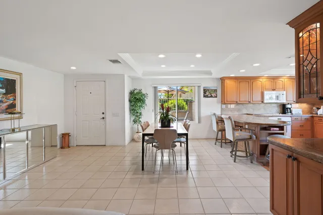 a dining hall with stainless steel appliances a dining table and chairs
