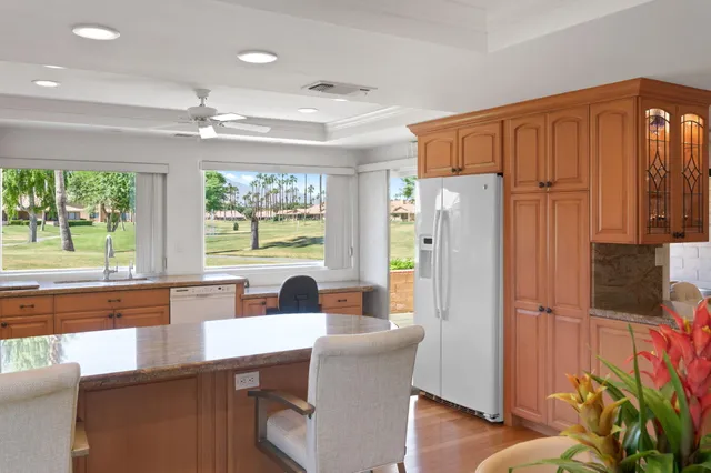 a kitchen with stainless steel appliances granite countertop a refrigerator a sink dishwasher with a dining table and chairs