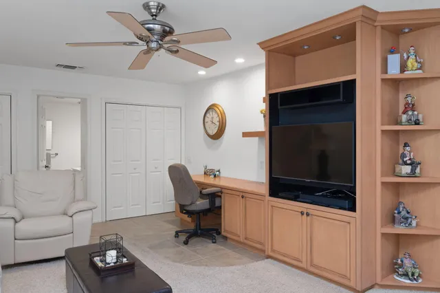 a living room with furniture a flat screen tv and a window