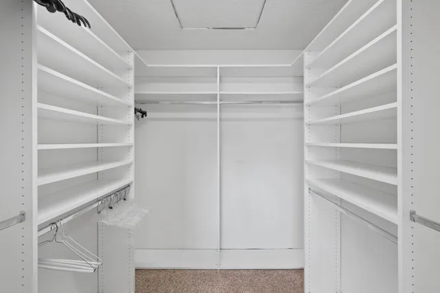 a view of walk in closet with empty racks