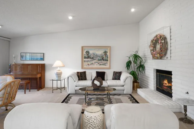 a living room with furniture a fireplace and a potted plant