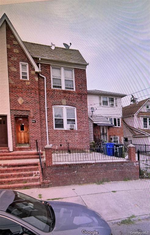 View of front of house with brick siding and a fenced front yard