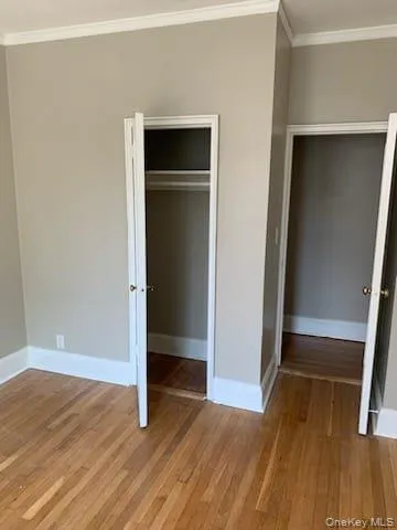 an empty room with wooden floor and closet